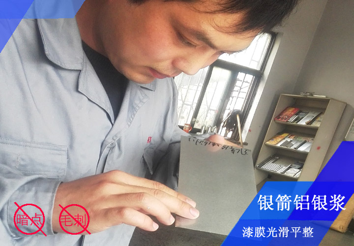 銀箭鋁銀漿工程師李工正在對(duì)發(fā)動(dòng)機(jī)殼烤漆漆膜看板檢測(cè)，確保漆膜光滑平整無暗點(diǎn)、無毛刺